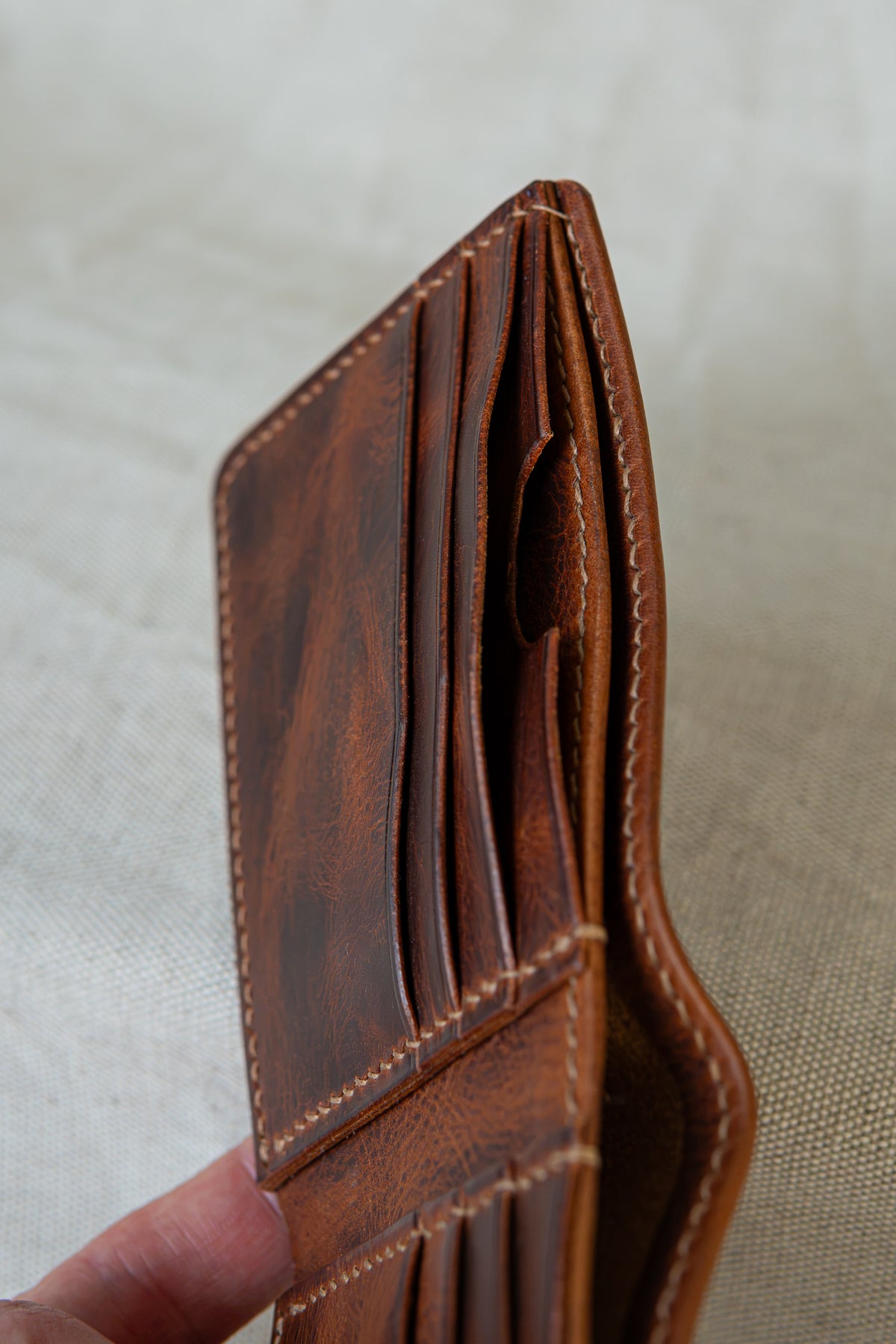 Portefeuille Tourmalet en cuir cognac, ouvert avec détails sur les poches