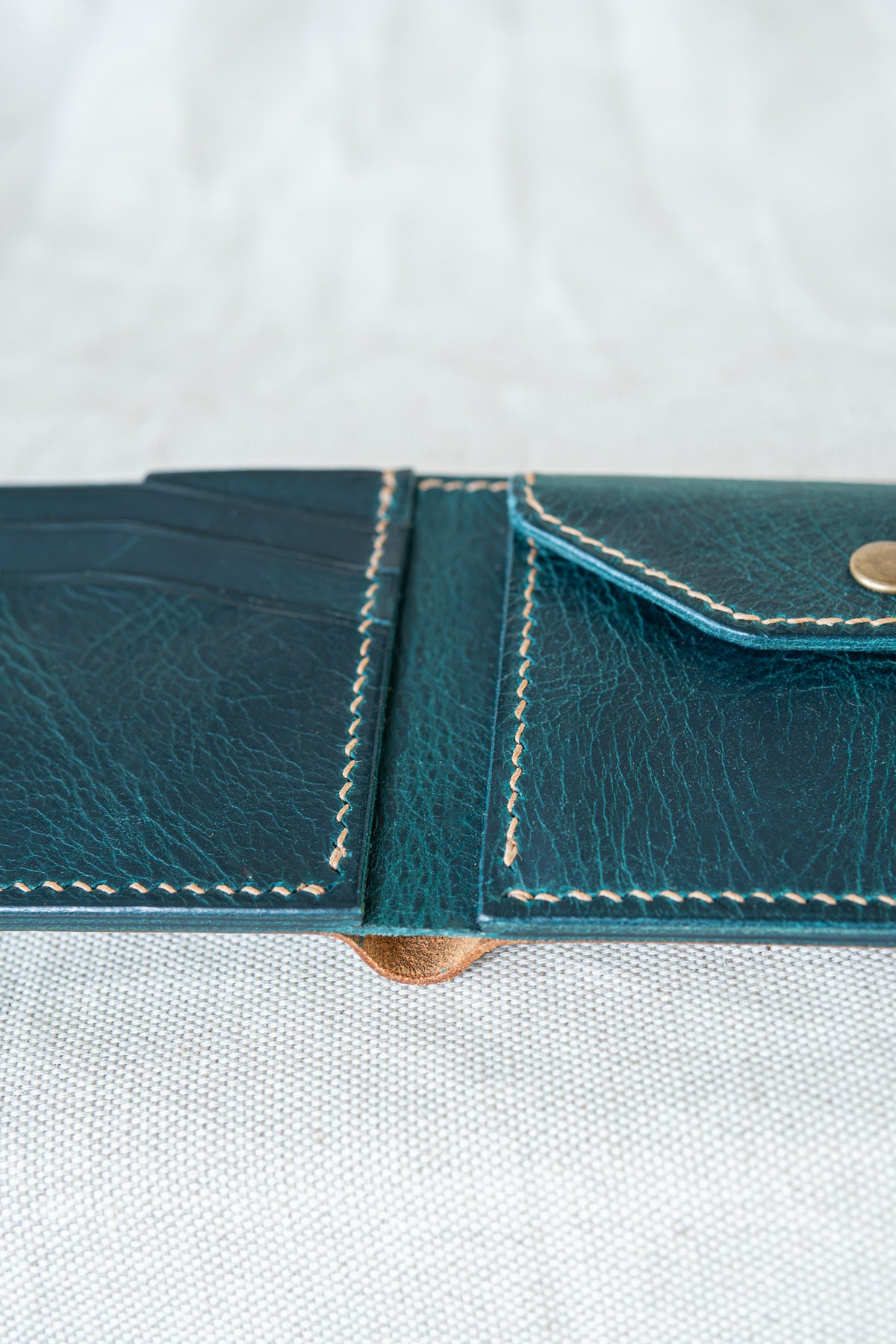 Portefeuille Vignemale en cuir cognac et turquoise, détail sur les coutures main au point sellier