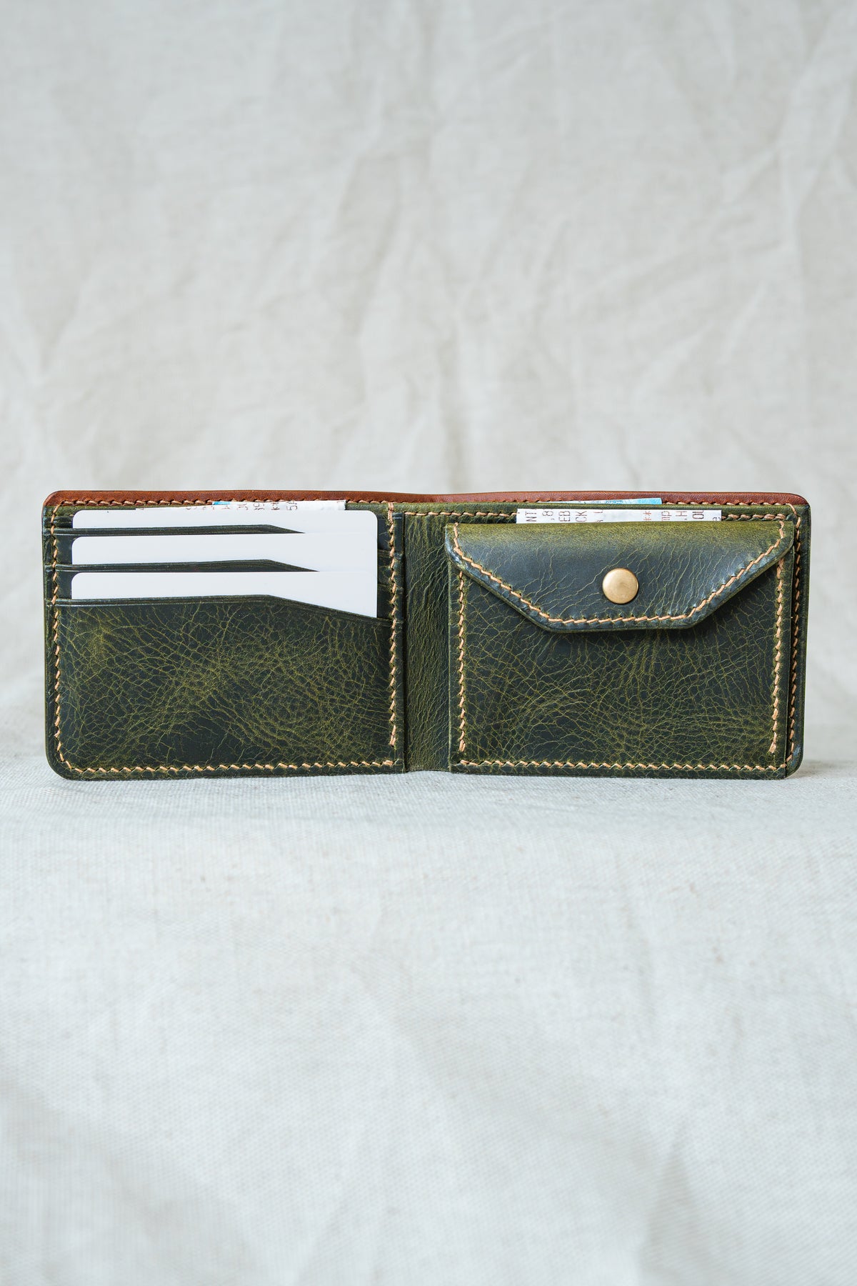 Portefeuille Vignemale en cuir cognac et olive, ouvert avec cartes et billets