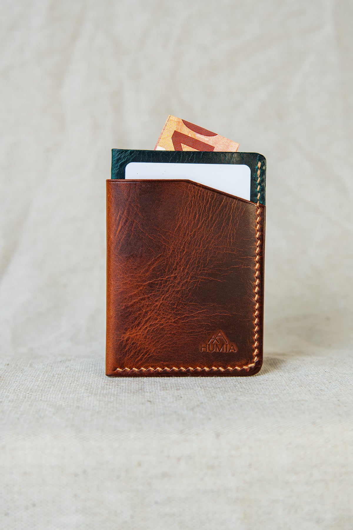 Porte-cartes Bastan en cuir cognac et turquoise, vue de face avec carte et billet