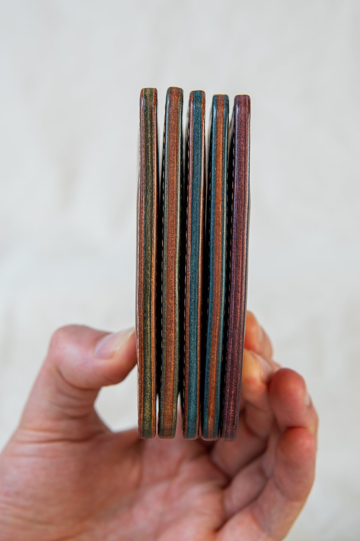 Porte-cartes Hautacam tenus en main, vue de la tranche, éventail de couleurs