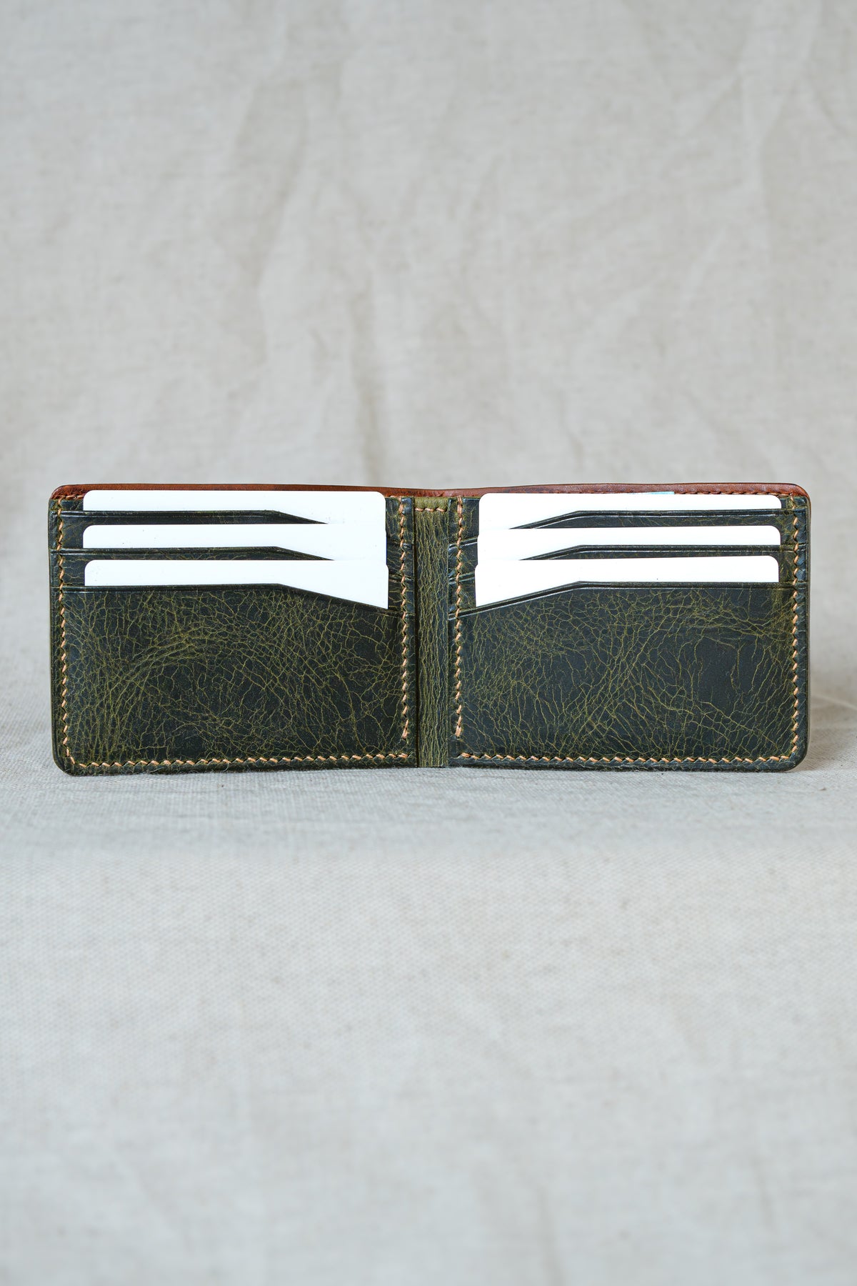 Portefeuille Tourmalet en cuir cognac et olive, ouvert avec cartes et billets