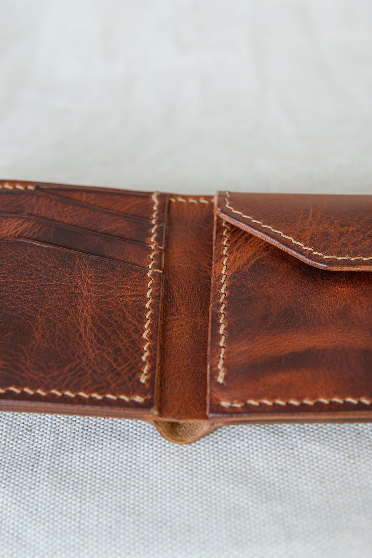 Portefeuille Vignemale en cuir cognac, détails sur les couture main au point sellier