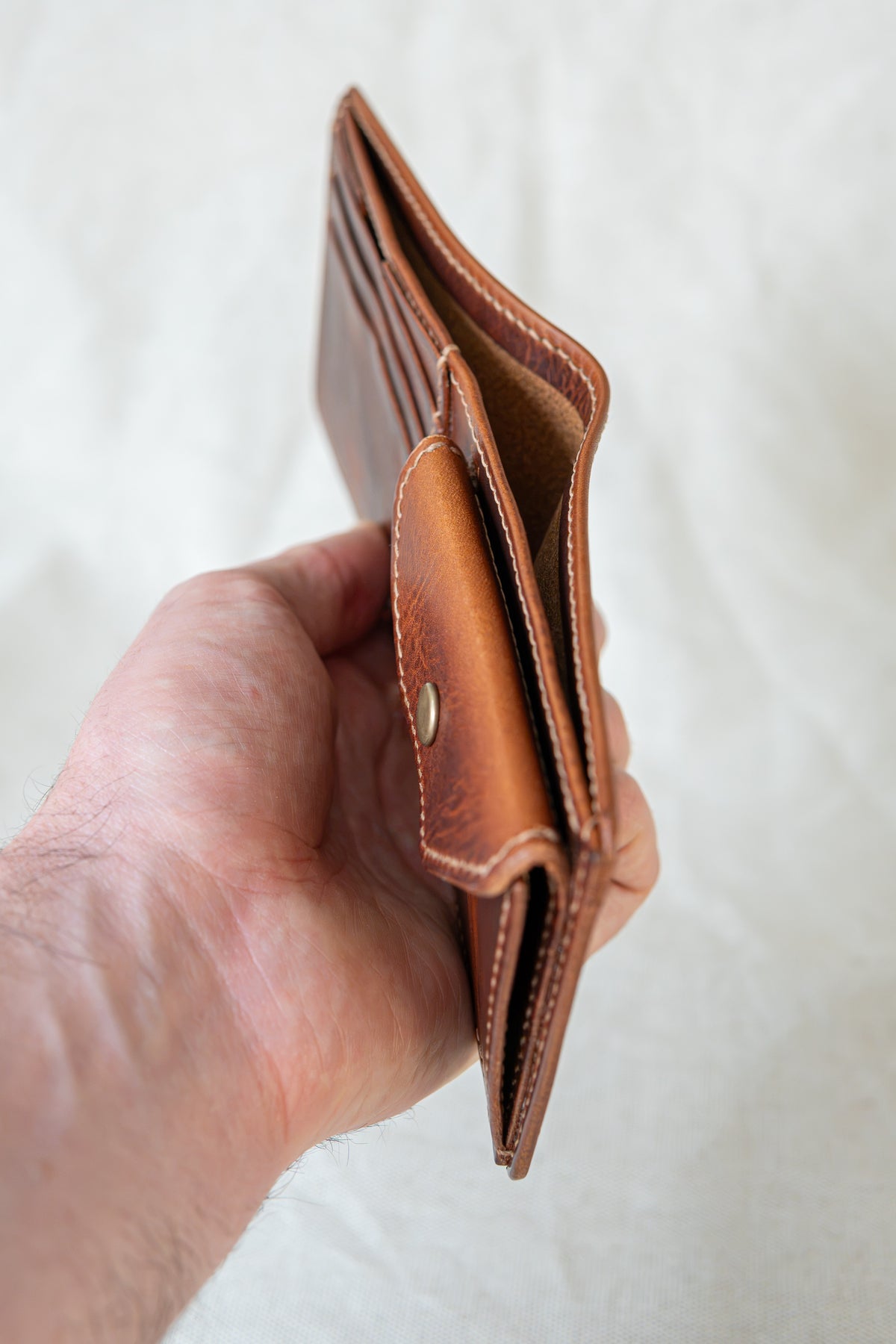 Portefeuille Vignemale en cuir cognac, tenu en main ouvert