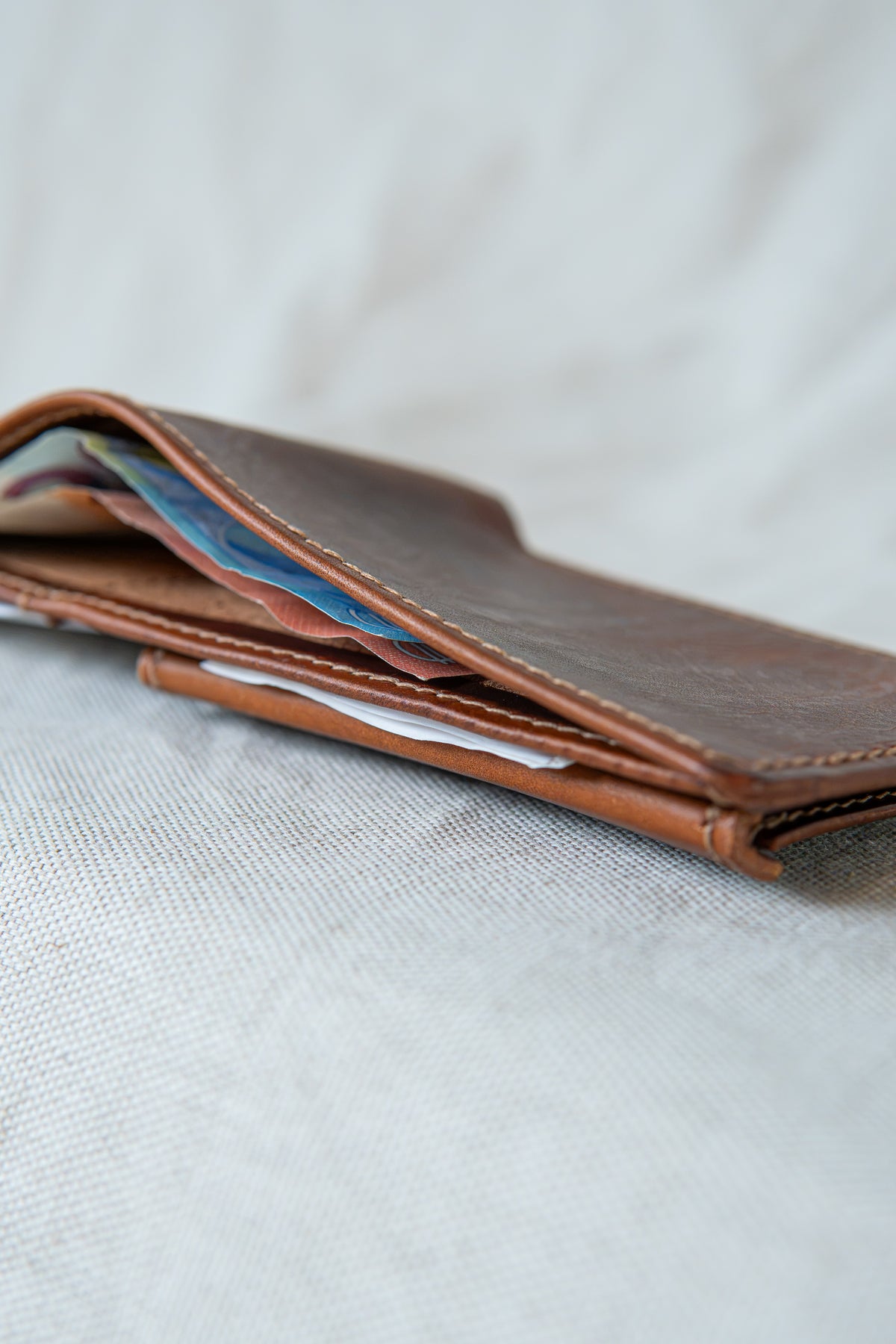 Portefeuille Vignemale en cuir cognac, posé ouvert avec cartes et billets